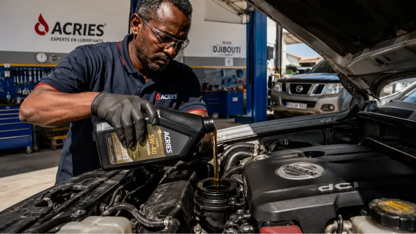 Huile moteur à Djibouti — technicien ACRIES effectuant une vidange sur un Nissan Navara dans l'atelier officiel ACRIES Djibouti