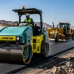 Chantiers routiers à Djibouti — rouleau compacteur Ammann ARX sur chantier d'enrobé avec niveleuse Komatsu, équipements distribués par ACRIES depuis 1946