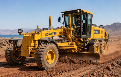 Niveleuse Komatsu à Djibouti — niveleuse Komatsu GD705 en opération sur chantier routier avec opérateur ACRIES